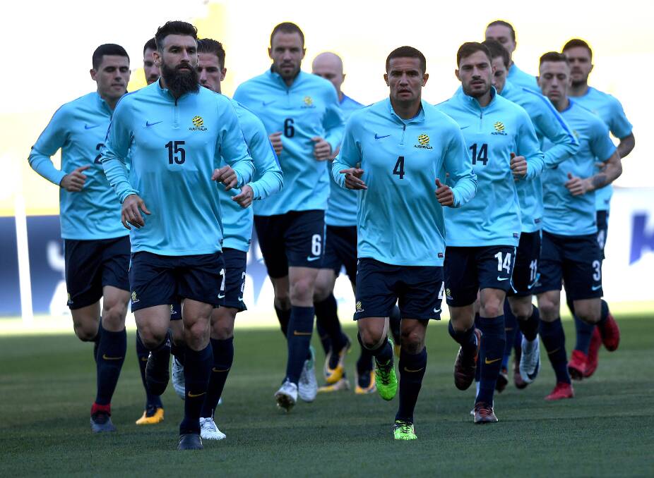 READY FOR BATTLE: Australian captain Mile Jedinak (left) jogs with his teammates at training . Picture: AAP