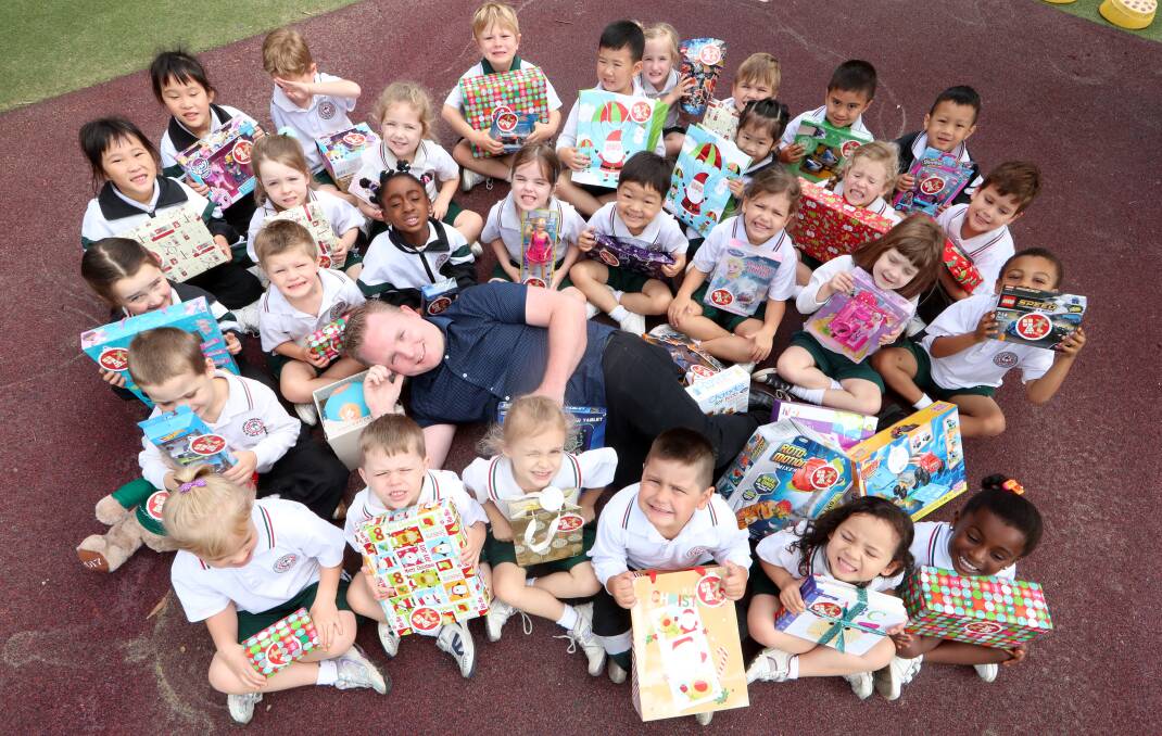 DONATING PRESENTS: Prep children (aged 3-5 years) at Illawarra Christian School with Target Warrawong assistant manager Matt Hastie. Picture: Sylvia Libe