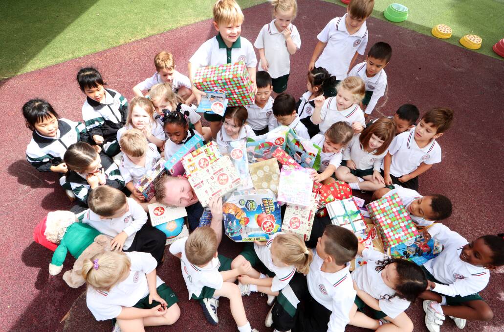 Prep children (aged 3-5 years) from Illawarra Christian School with Target Warrawong assistant manager Matt Hastie. The kids donated gifts to the Target/Uniting Care Christmas appeal. Picture: Sylvia Liber