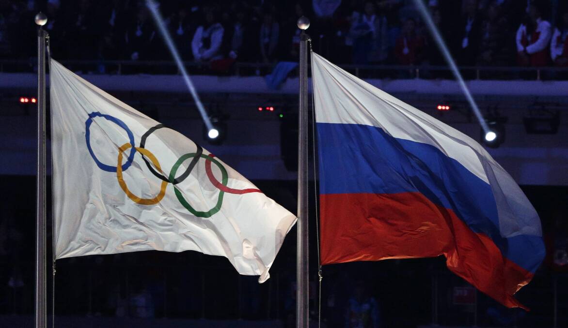 The Russian and Olympic flags during the closing ceremony of the 2014 Winter Olympics in Sochi, Russia. Picture: AP Photo/Matthias Schrader