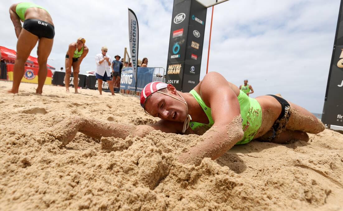 GIVE IT ALL: Mermaid Beach Ironman Luke Cuff recovers in the North Beach sand after crossing the finishing line on Sunday afternoon. Picture: ADAM McLEAN