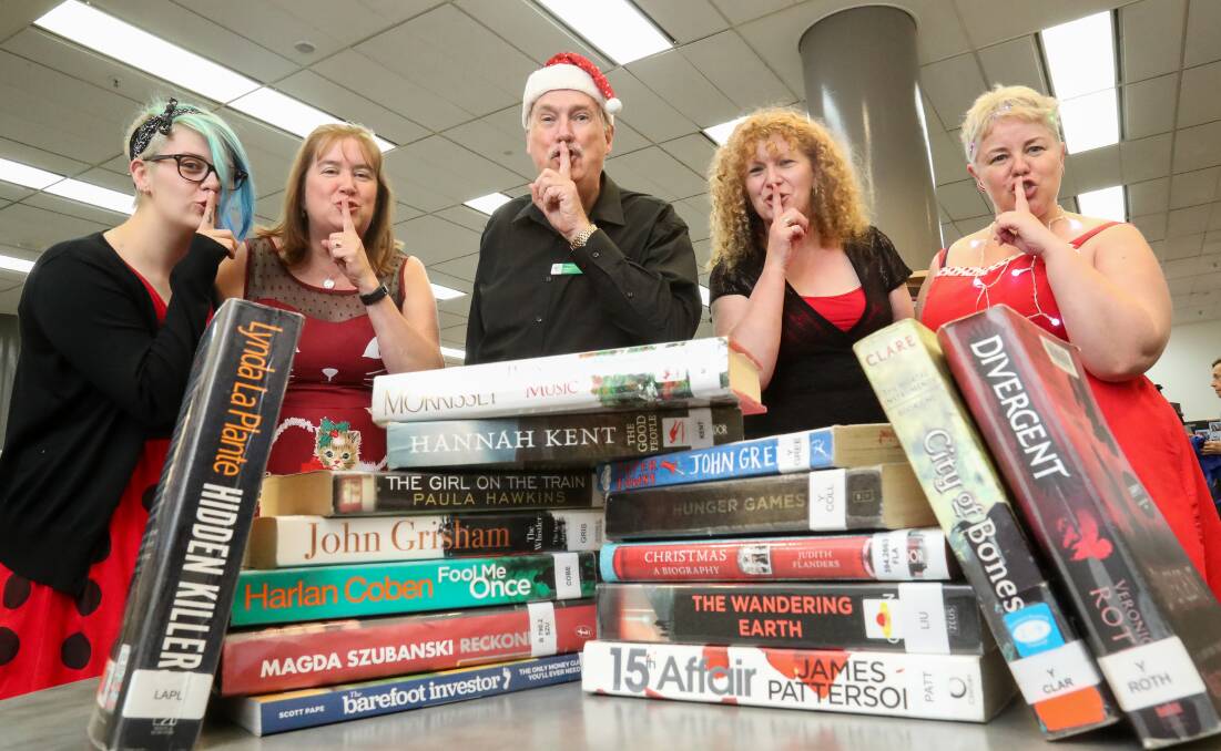WELL READ: Steph Daly, Liz Astley, Mark Norman, Lee Burgoyne and Stacey Wales with some of the most borrowed books from Wollongong City Libraries in 2017. Picture: Adam McLean