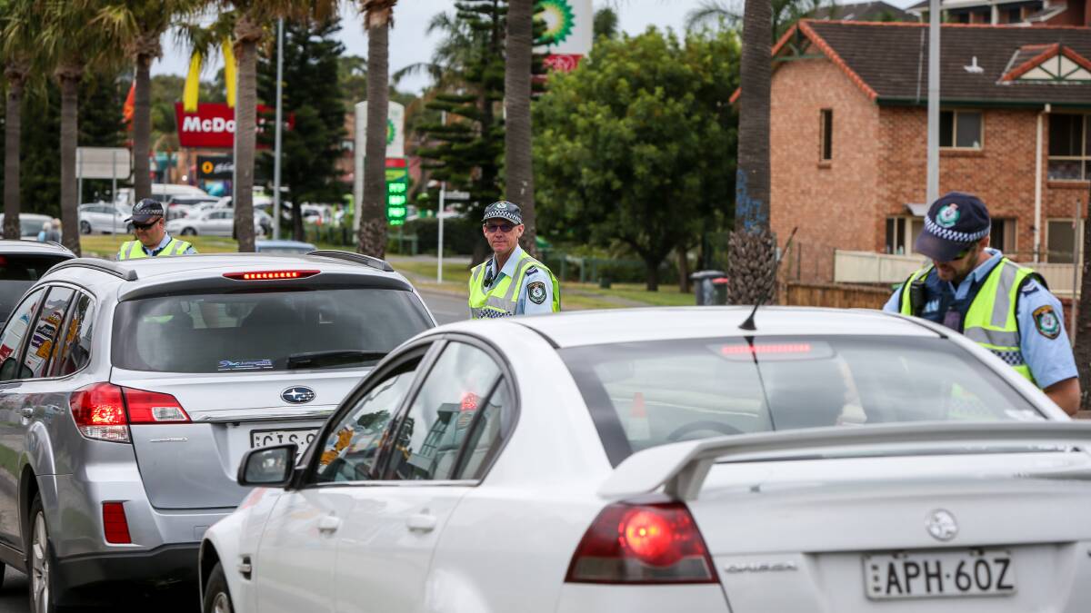 A Wollongong police officer conducting a random breath test on the Princes Highway at Fairy Meadow, Tuesday morning. Picture: Georgia Matts
