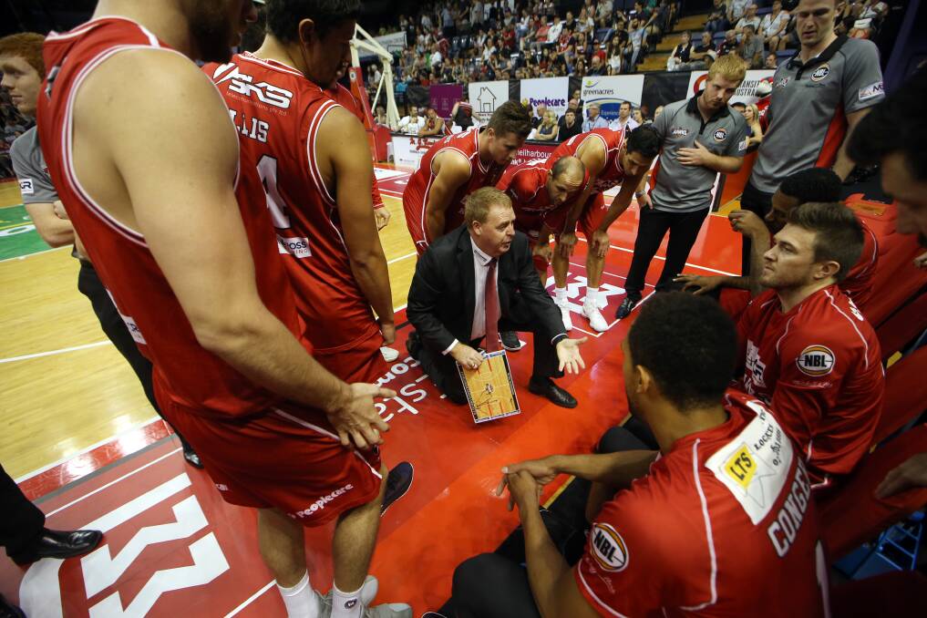 STICK TOGETHER: The Illawarra Hawks squad stand in a huddle around coach Rob Beveridge during their New Year's Eve clash against Brisbane. Picture: Sylvia Liber.