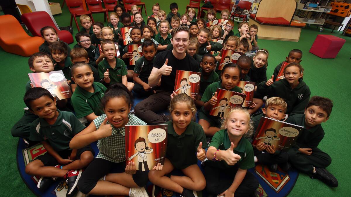 KING OF THE KIDS: The Voice 2013 winner Harrison Craig with Warrawong Public School students. He read from his book Harrison's Song. Picture: Robert Peet