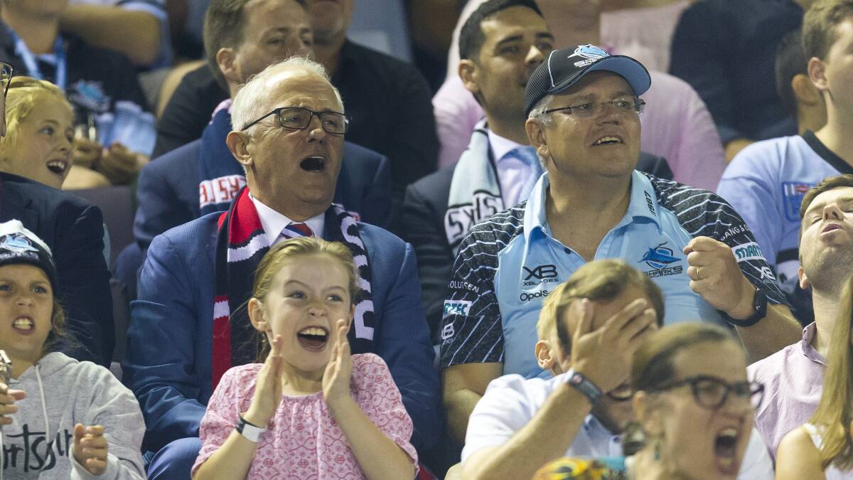 Twist and shout: Malcolm Turnbull with Scott Morrison at the footy. Picture: AAP Image/Craig Golding