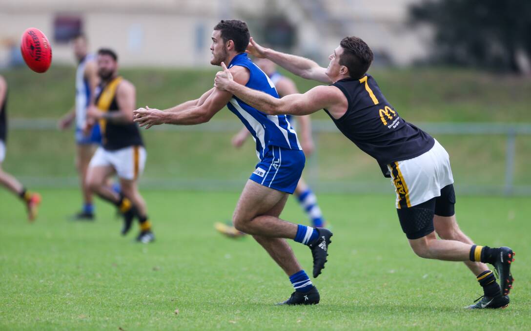 Hands off: Figtree's Nick Stacey hand-passes before being tackled by Bomaderry's Courtney Ward. Picture: Georgia Matts