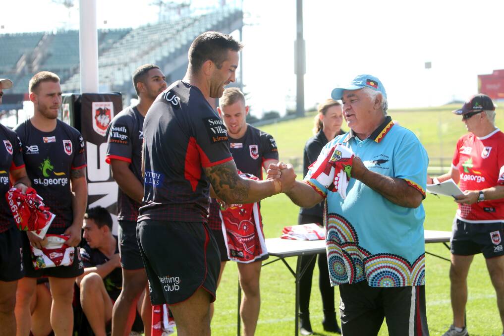SPECIAL: llawarra Koori Men’s Support Group's Uncle Gerald Browne presents Paul Vaughan with his Indigenous Round jumper. Picture: Sylvia Liber. 