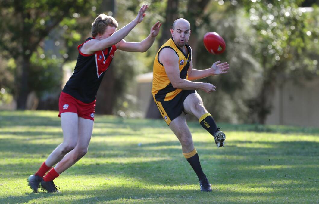 Unde pressure: Northern Districts' Kym Allen kicks close the boundary at Hollymount Park on Saturday. Picture: Sylvia Liber