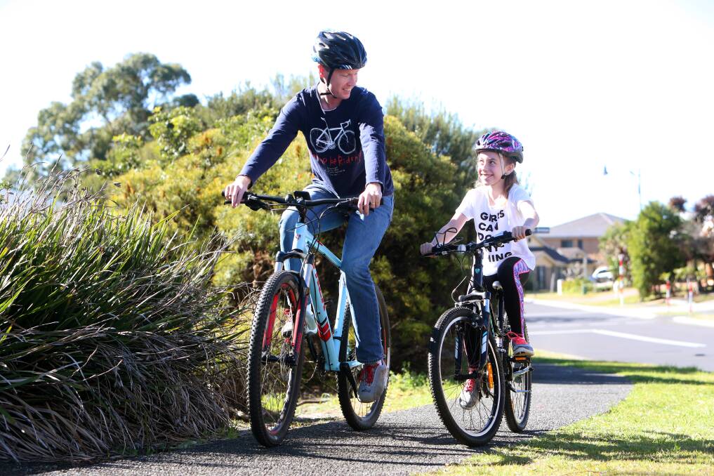 Rule change: Adrian Hodgson cycling with daughter Isabelle, who will now be able to ride on the footpath until she turns 16 after the government changed a law. Picture: Sylvia Liber