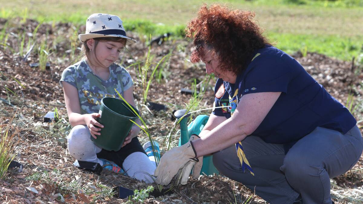 DIGGING IN: Lucy Lewin and Sharon-Lea Causer from Dapto Scouts plant trees at Greenhouse Park in Wollongong on National Tree Day. Picture: Robert Peet