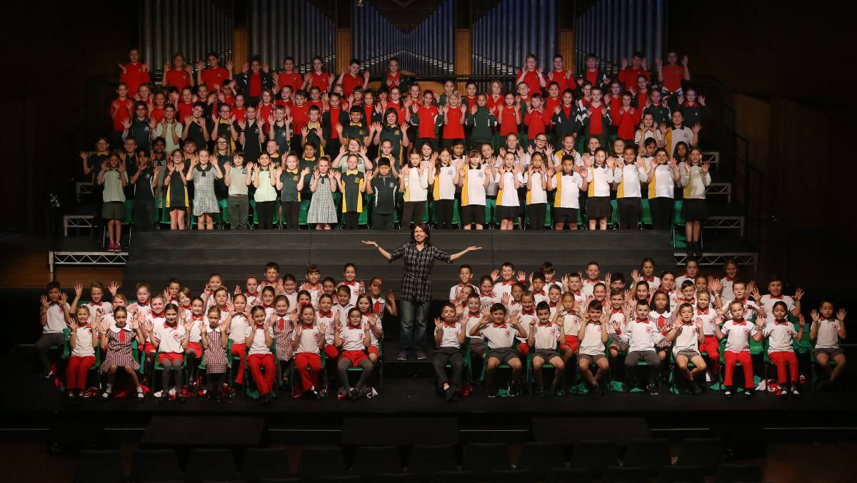 ON SONG: School students with Wollongong Choral Festival musical conductor Susie Hamers at Wollongong Town Hall. Picture: Robert Peet