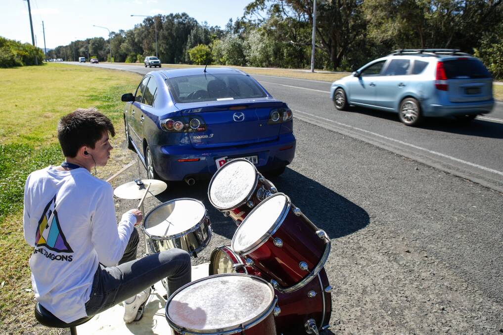 Finley Ford playing his drums on the side of Squires Way in North Wollongong. Picture: Adam McLean