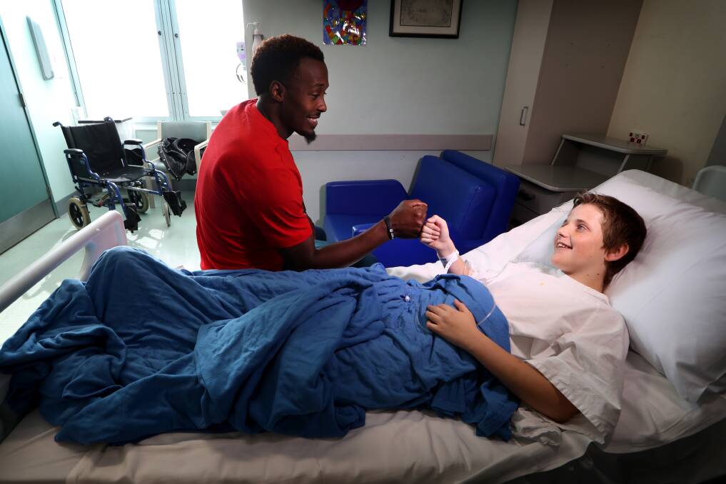 OUT IN THE COMMUNITY: New Illawarra Hawks guard Cedric Jackson with Kynan Spence in the Children's Ward at Wollongong Hospital on Monday afternoon. Picture: Sylvia Liber