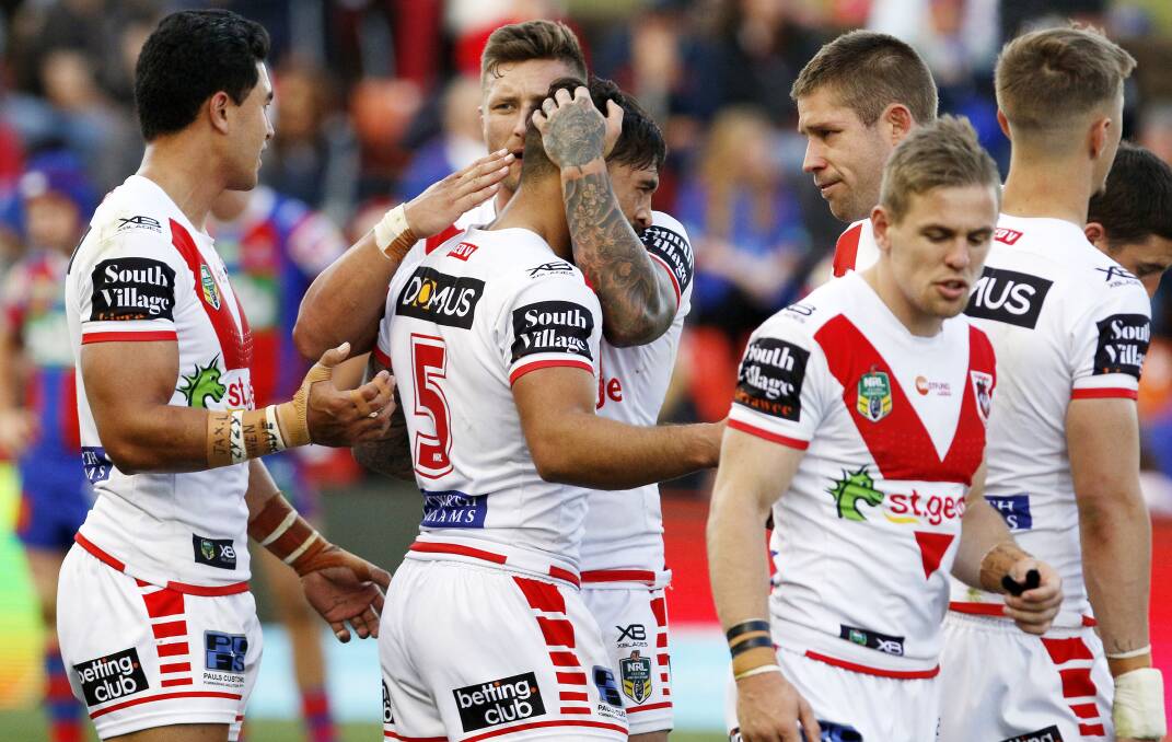 GOOD SHOT: Dragons winger Jordan Pereira is mobbed by teammates after his hit on Knights forward Mitch Barnett in round 25. Picture: AAP 