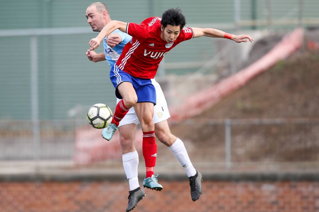 KNOCKOUT: Albion Park White Eagles attacker Hikaru Kawasakiya leaps for the ball alongside Wollongong Olympic's Jack Keating. Picture: ADAM McLEAN