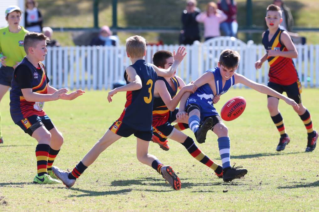 Contest: Figtree's Jacob Hosking attempts a clearing kick in Sunday's grand final. Picture: Sylvia Liber.