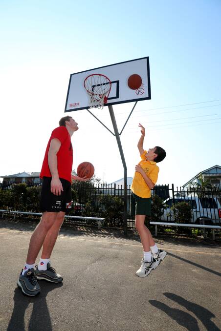 Moving on up: Stella Maris Primary School student Caiden Judd gets some shooting tips from new Illawarra Hawks recruit Daniel Grida at Shellharbour Village on Monday after school. Pictures: Sylvia Liber.

