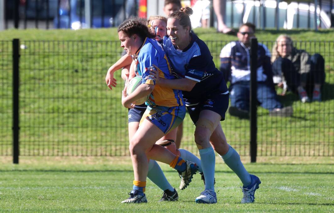 Bruising encounter: Victoria's Jessica Cox is tackled during the final of the Australian Police Rugby Union championships on Saturday. Picture: Sylvia Liber.