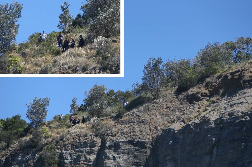 Danger zone: People posing for a photo at Sea Cliff Bridge just 48 hours after a man fell to his death at the same location. A bushwalking website has provided directions to the location. Photo: Adam McLean