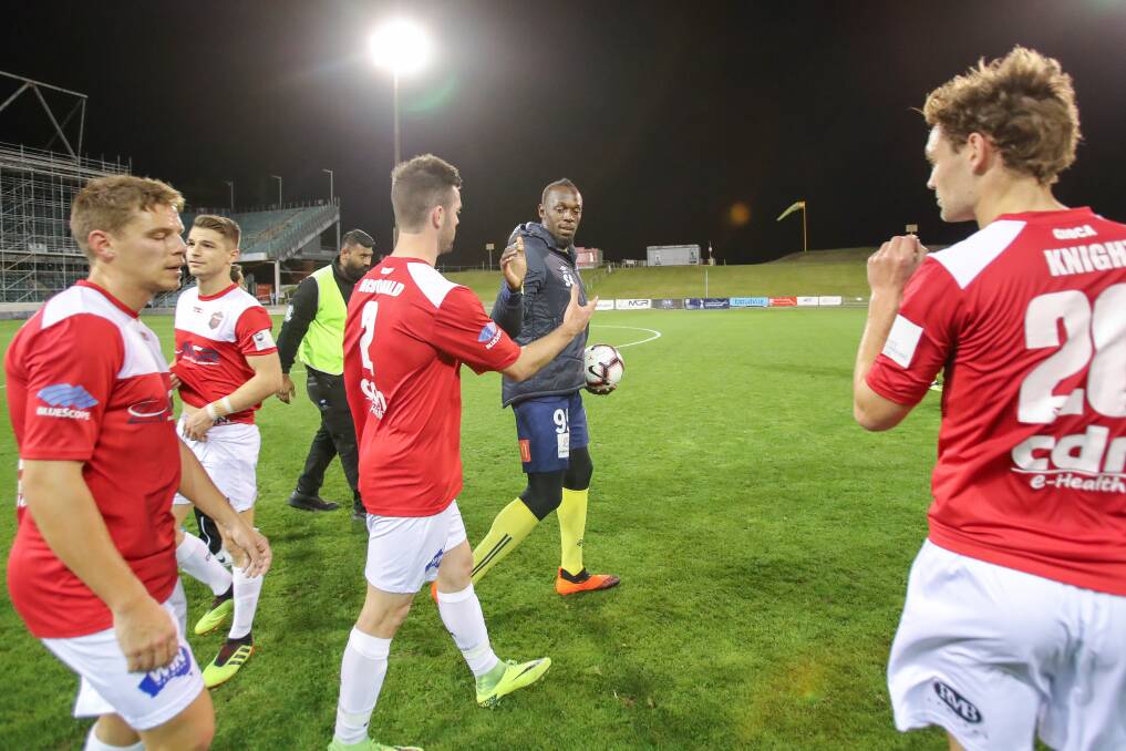 Fast and the furious: The Wolves and Usain Bolt at WIN Stadium after a friendly game in October. Picture: Adam McLean
