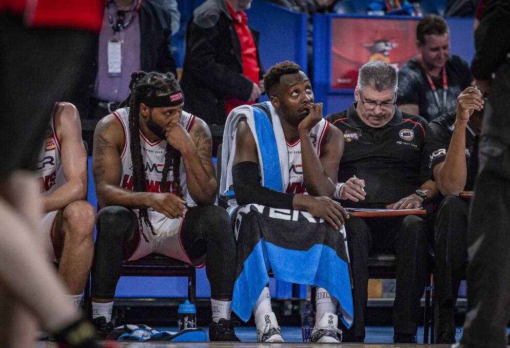 DEJECTED: Jordair Jett and Cedric Jackson look on from the bench during the Hawks 40-point loss to Perth in round one. Picture: AAP 