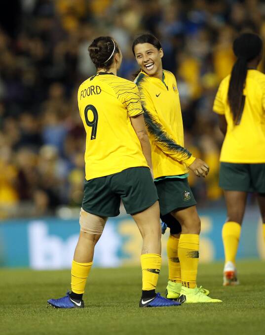 All smiels: Sam Kerr (right) and Caitlin Foord of the Matildas celebrate their win over Chile in November. Picture: AAP Image/Darren Pateman