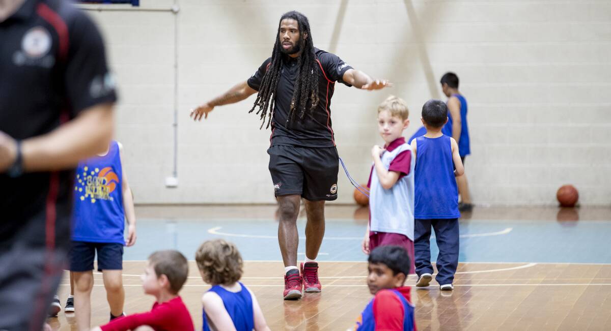 HOME AND AWAY: Hawks guard Jordair Jett participates in a clinic for young Canberran basketballers at Belconnen Basketball Stadium. Photo: Sitthixay Ditthavong
