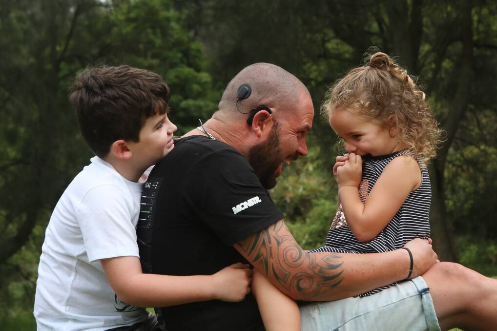 Switched on: Michael Drury, pictured with his children Piper and Rhys, lost his hearing after a serious accident last March but Monday marked a milestone with the activation of his second cochlear implant. Picture: Sylvia Liber