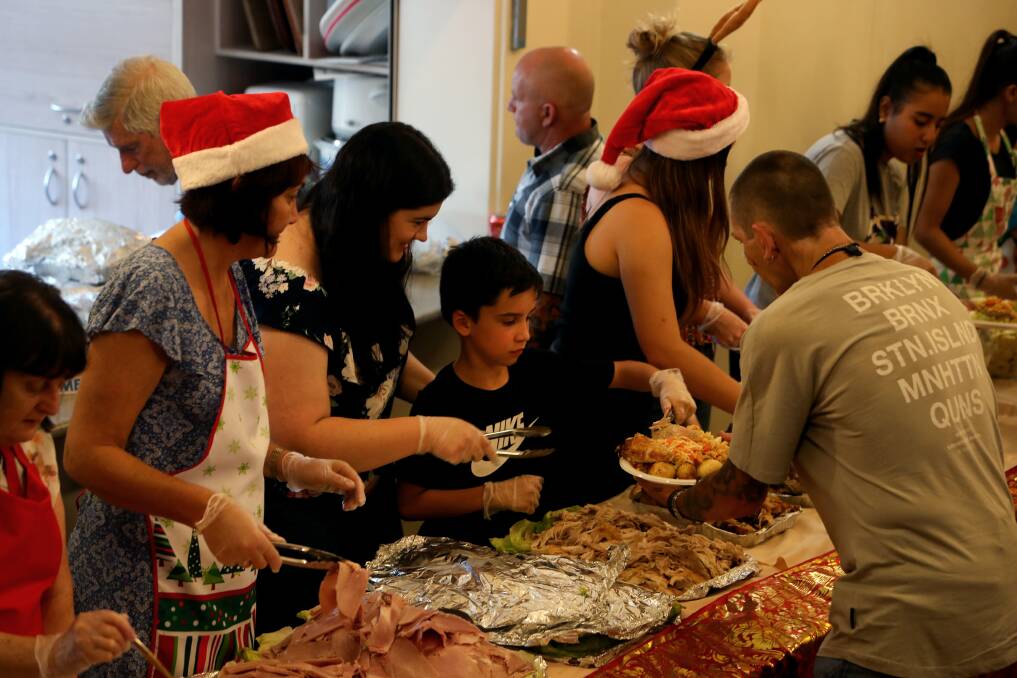 FLASHBACK: Volunteers at Wesley Uniting Church Wollongong dish out a Christmas Day feats in 2018 to people less fortunate. This year it will be take-away lunches handed out on Christmas Eve. Picture: Sylvia Liber