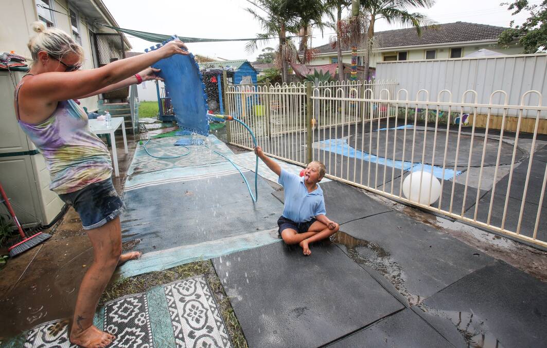 Water world: Jack Podesta uses a hose to cool down this week with mum Carol-lee while waiting for his pool to be refilled, after a bunch of locals worked hard to make it compliant with fencing laws. Picture: Adam McLean