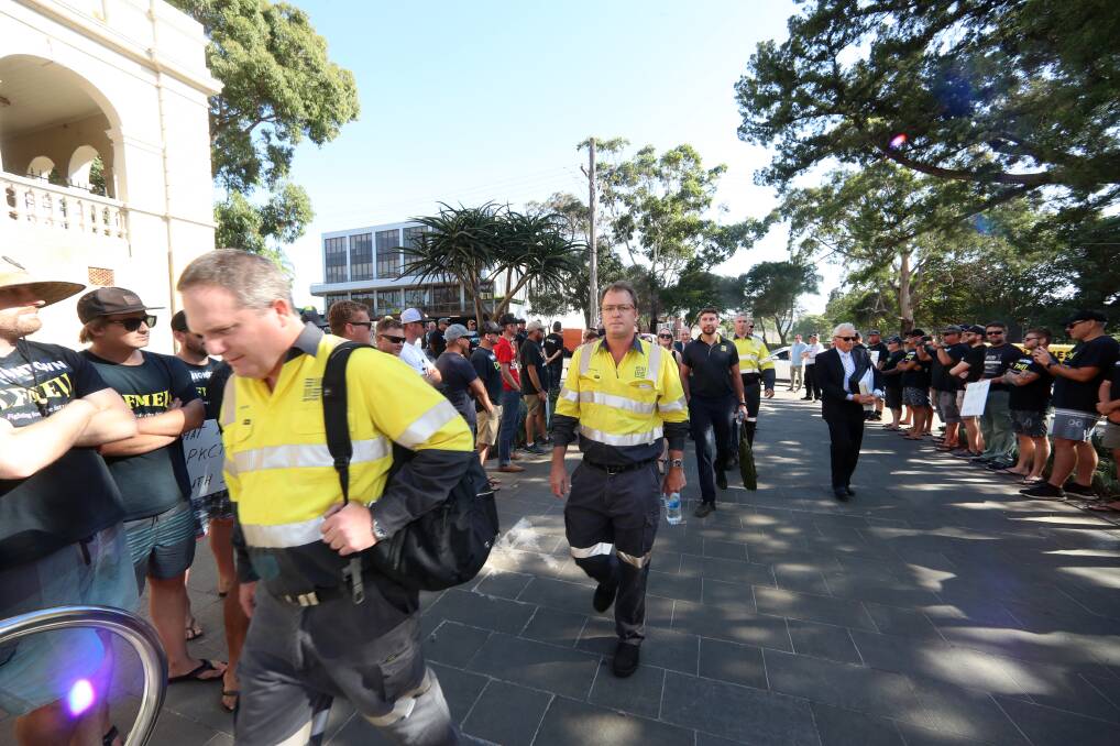 Protest: South32 representatives walk through the "guard of dishonour" formed by Port Kembla Coal Terminal workers outside Wollongong Court. South32 is part-owner of the coal terminal. Picture: Sylvia Liber