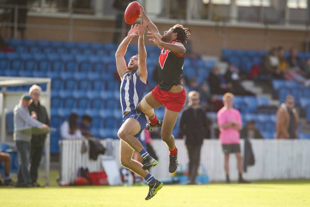 Rising up: Kuiam Anu leaps at the contest with Figtree's Nick Stacey in Saturday's game at North Dalton Park. Picture: Adam McLean