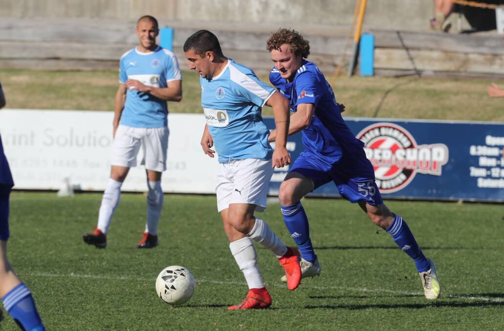 In front: Joey Lavalle in possession for Wollongong Olympic, as he is pursued by Bulli's Luke Foster. Picture: Robert Peet