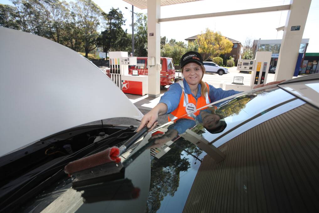 Service: Driveway concierge Lisa Schilling at work on the forecourt of the Caltex service station at West Wollongong. The station has gone back in time to offer customers driveway service