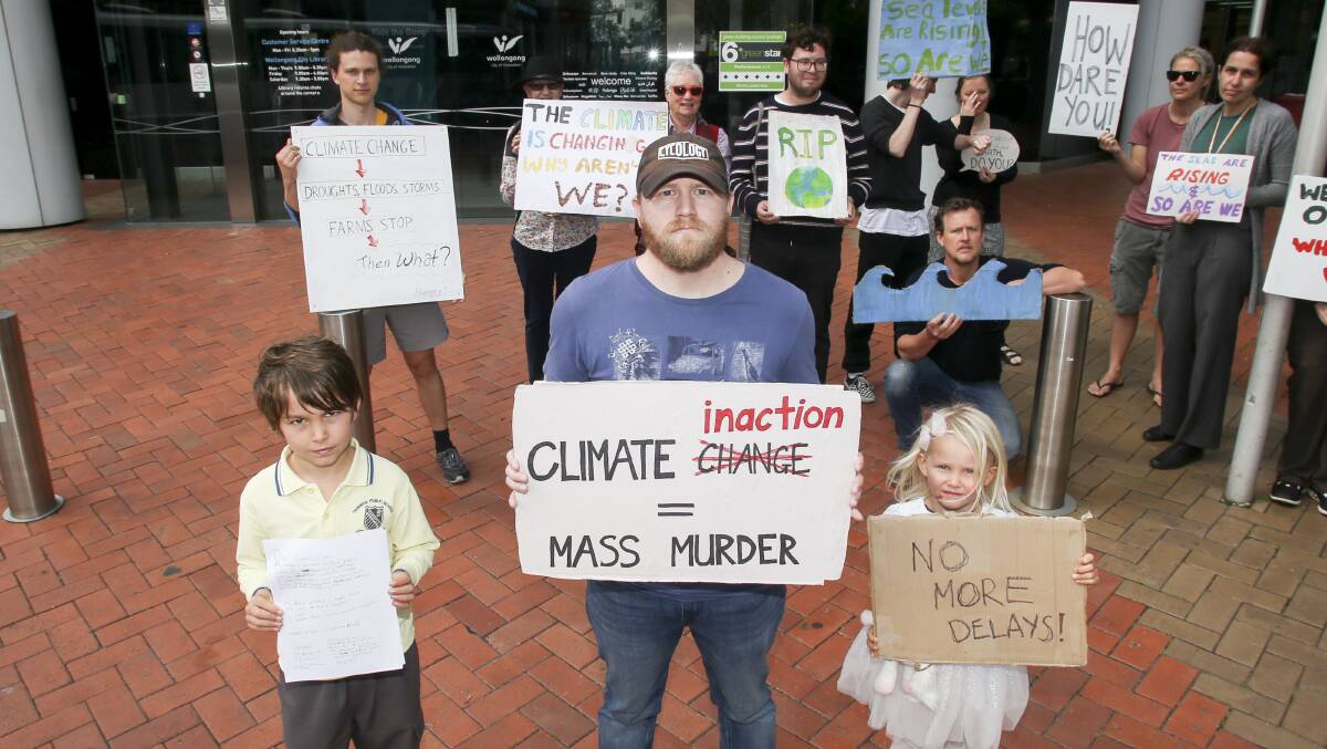 NOT HAPPY: Illawarra Climate Justice Alliance organizer Ben Gava, pictured in front of Wollongong Council offices with Leo Park and Meg Park 4, says politicians aren't doing enough to achieve climate justice. Picture: Anna Warr