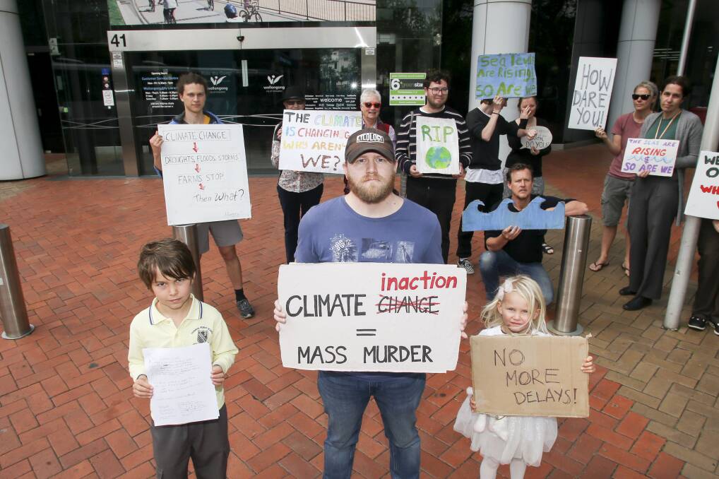 Leo Park, 9, Youth Environmental Alliance member Ben Gava and Meg Park, 4 with others outside Wollongong City Council's premises, protesting the council's decision to delay climate action. Picture: Anna Warr