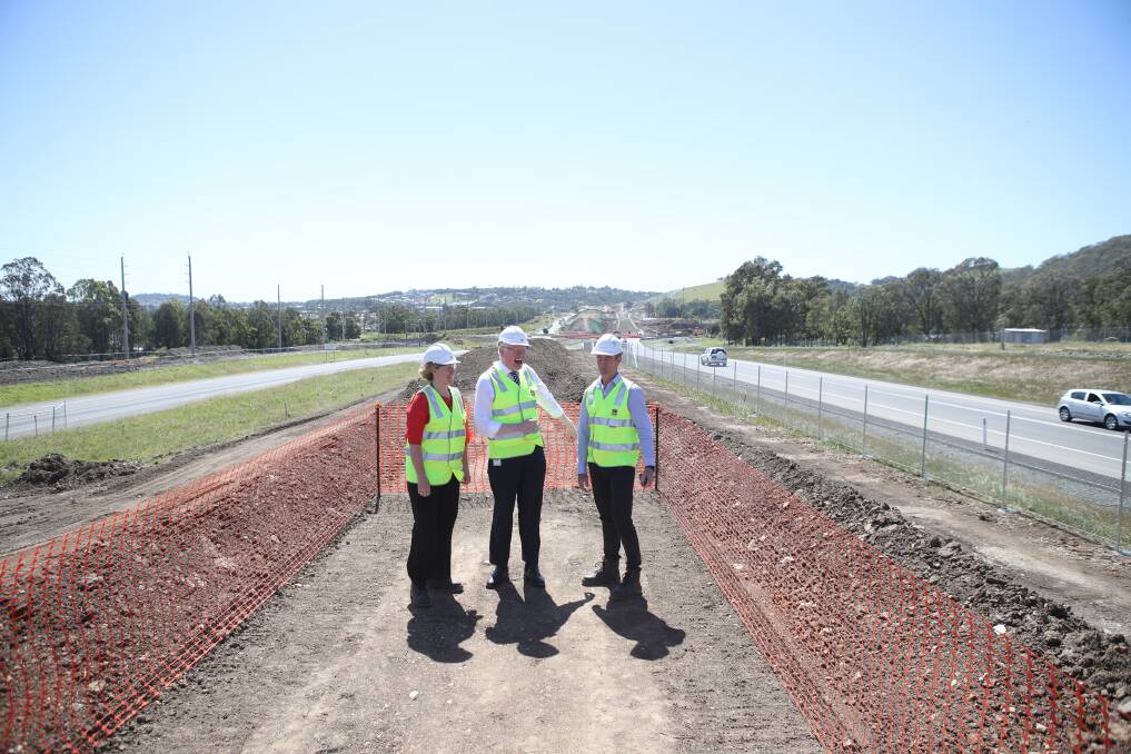 Kiama MP Gareth Ward (centre) on the Albion Park Rail bypass site with Southern region director Sam Knight (left) and project manager Adrian Rouse with the first section of the bypass to open at the right. Picture: Adam McLean