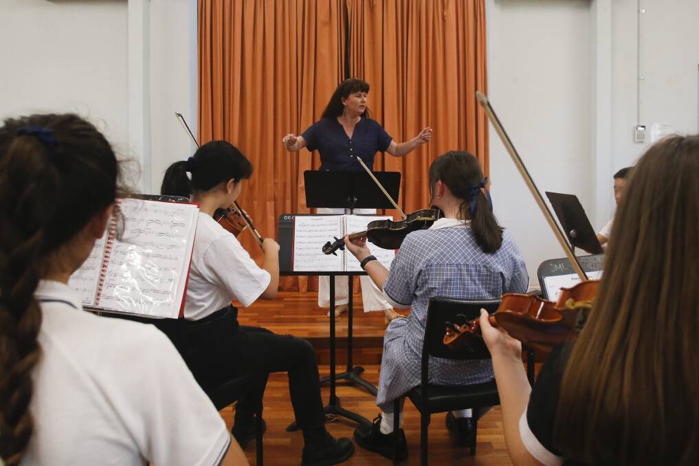 Powell Strings conductor Tanya Phillips leading the orchestral group in rehearsal.