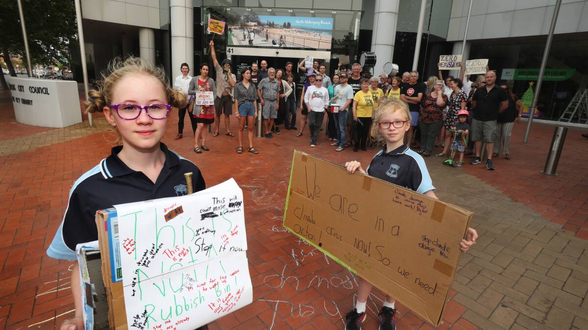 CLIMATE RALLY: Lily Prior and Isabelle Prior with members of Illawarra Climate Justice Alliance outside the Wollongong Council chambers. Picture: Robert Peet