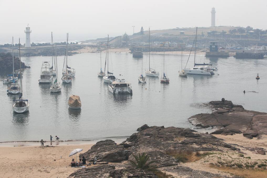 GREY ZONES: The sailing boats linger as Belmore Basin in Wollongong is shrouded by smoke on Thursday morning. Picture: Adam McLean.