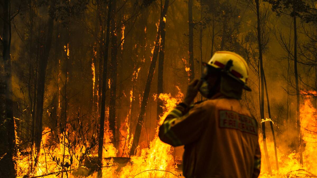 NSW Rural Fire Service firefighters protect a property on Tallow Wood Road, west of Ulladulla, from the Currowan fire in catastrophic conditions on December 21. Picture: Dion Georgopoulos