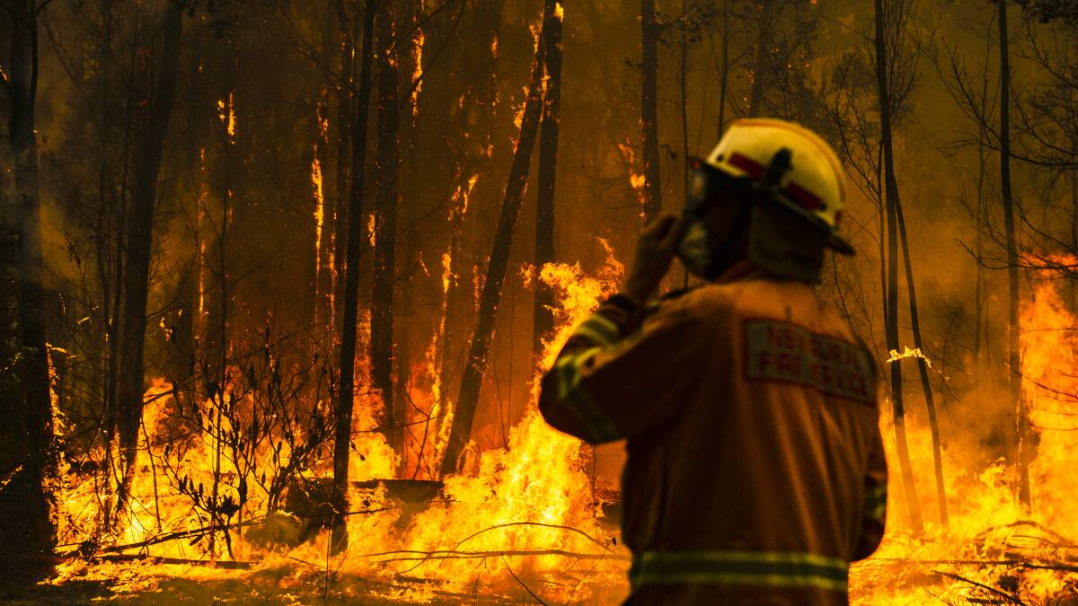NSW Rural Fire Service firefighters come to protect a property on Tallow Wood Rd from the Currowan Fire on Saturday, December 21. Picture: Dion Georgopoulos