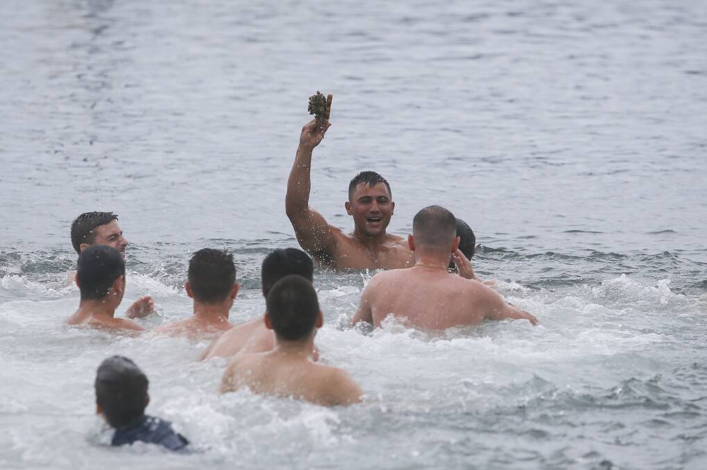 Luck: Josh Kostadinovski holds up the cross he retrieved from the waters of Belmore Basin, earning a lifetime of good fortune. Picture: Anna Warr