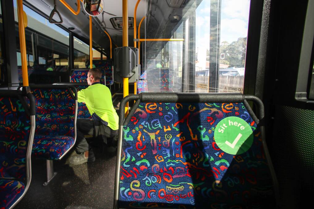 Changes: Steven Noble from Dions Bus Company placing the new green social distancing stickers on the fleet's bus seats. Picture: Adam McLean.
