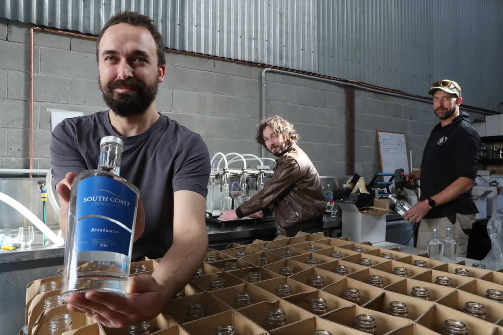 Cheers: Oskar Schwab, Luke Harding and Brett Mainon hard at work at South Coast Distillery bottling their award-winning Breakwater Navy Strength gin. Picture: Robert Peet