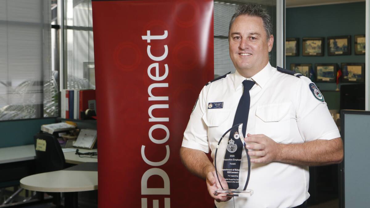 HUMBLED: EDConnect employee and Dapto RFS Deputy Captain, Bill Reid, holds the award given to EDConnect for being a supportive employer. Picture: Anna Warr