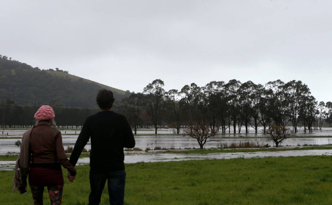 John Neville and Linda Sattleker looking at flash flooding at Jamberoo on Saturday. Picture: Sylvia Liber