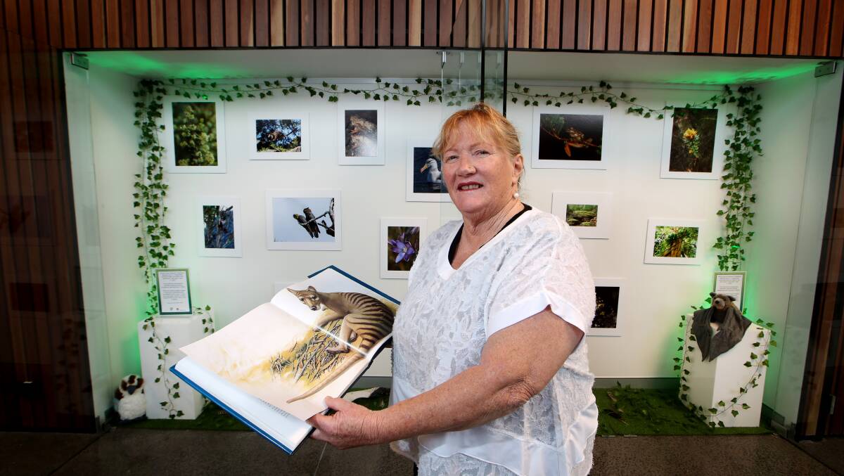 Shellharbour Mayor Marianne Saliba holds a book including the Tasmanian Tiger at the new photographic exhibition. Picture: Sylvia Liber.