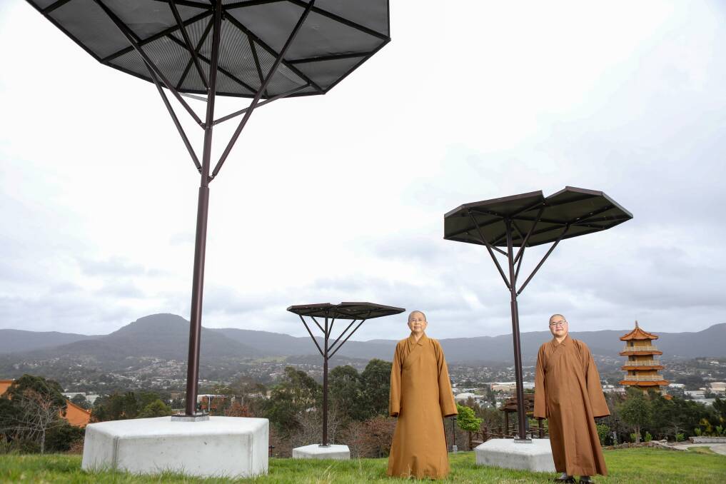 ARTY: Venerable Manko and Venerable Youji stand amongst sculptures gifted by Mignon Steele to the Nan Tien Temple, which will feature as part of their new outdoor sculpture festival. Picture: Adam McLean